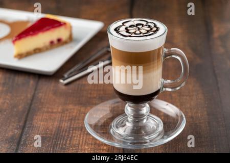 Latte à café multicouche dans une tasse en verre sur une table en bois Banque D'Images