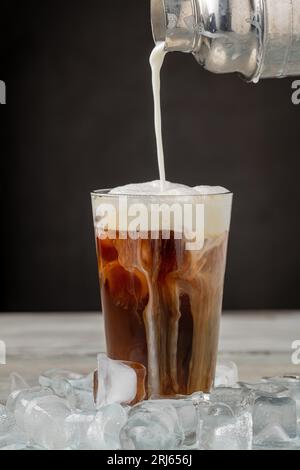 Café glacé latte dans une tasse en verre sur une table en bois Banque D'Images