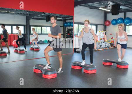 Groupe de personnes la flexion jambes sur les plates-formes étape Banque D'Images