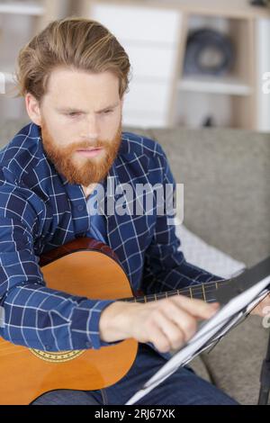 homme jouant de la guitare dans le bureau Banque D'Images