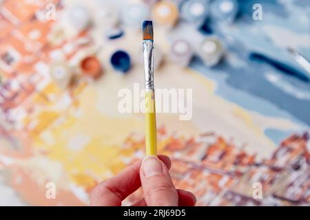 Activités adultes est colorier une image par des chiffres. La femme tient une brosse. Banque D'Images