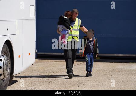 LE visage de l'enfant a été pixélisé car le bureau photo de PA n'a pas pu obtenir l'autorisation nécessaire pour photographier un enfant de moins de 16 ans sur des questions concernant son bien-être. Un groupe de personnes considérées comme des migrants est amené à Dungeness, Kent, par un canot de sauvetage RNLI à la suite d'un incident de petit bateau dans la Manche. Date de la photo : lundi 21 août 2023. Banque D'Images