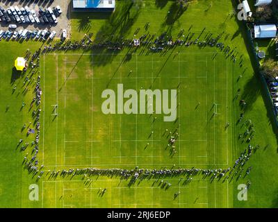 Un terrain de football bondé avec un gazon verdoyant et verdoyant, avec un grand nombre de spectateurs debout sur les lignes de touche Banque D'Images