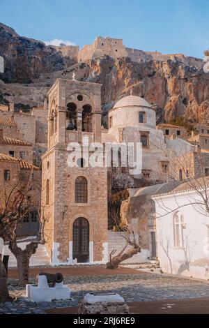 Église en ville avec vue sur la falaise de montagne sur la ville de Monemvasia Grèce Peninsula Péloponnèse avec arbres et canon, Holy Religious place Upright format, eu Banque D'Images