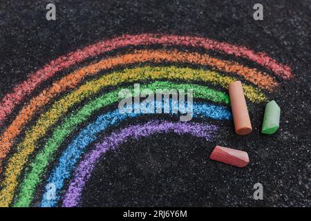 Gros plan d'un arc-en-ciel coloré peint sur une route avec de la craie de trottoir, photographié d'en haut Banque D'Images