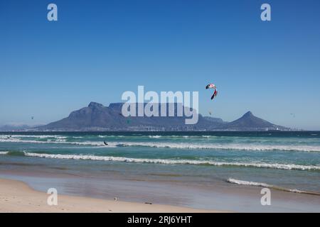 Célèbre Table Mountain Cape Town paysage en Afrique du Sud au coucher du soleil vu de Bloubergstrand avec kite surfeurs Banque D'Images