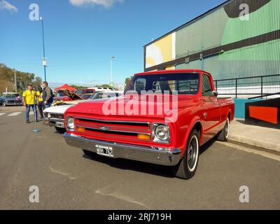 Vieux camion rouge 1967 Chevrolet C10 dans la rue. Fond industriel coloré. Salon des voitures anciennes Banque D'Images