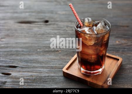 Un verre de Cola avec de la glace sur la table en bois, espace de copie pour le texte Banque D'Images