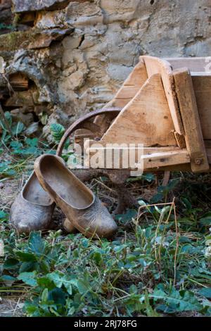 Scène rurale, sabots en bois reposant sur une brouette de travail dans une cour d'une maison castillane Banque D'Images