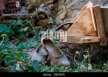 Scène rurale, sabots en bois reposant sur une brouette de travail dans une cour d'une maison castillane Banque D'Images