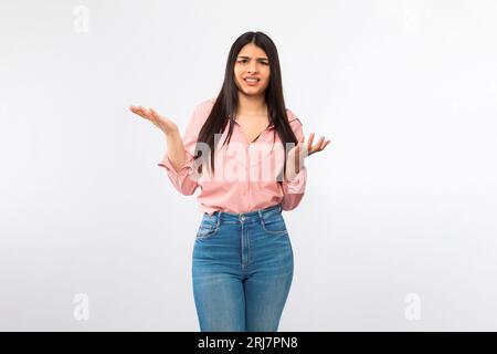 Mécontent Young Lady haussant les épaules debout sur fond de studio blanc Banque D'Images