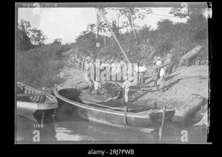 Grupo de Trabalhadores e Guindaste em Obras de Construção na Margem de Rio - 1155 1910 par Dana B. Merrill Banque D'Images