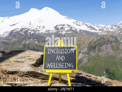 Symbole d'inclusion et de bien-être. Mots conceptuels inclusion et bien-être sur beau tableau noir de craie. Beau fond de montagne Elbrus. Motivationa Banque D'Images