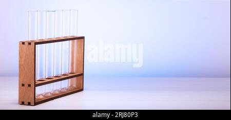 Tubes à essai en verre vides sur un support en bois sur la table. Tubes de verre vides pour les tests en laboratoire. Banque D'Images