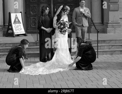 Une mariée et ses préposés se préparent à être photographiés devant une église après un mariage à Santa Fe, au Nouveau-Mexique. Banque D'Images