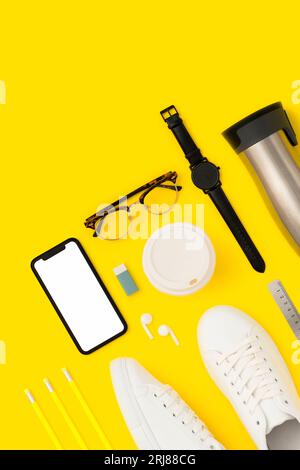 Retour à l'école plat avec maquette de téléphone intelligent sur fond jaune Banque D'Images