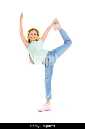 Petite fille dans les écouteurs dansant sur fond blanc Banque D'Images