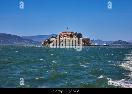Eaux agitées autour de l'île d'Alcatraz avec bateau d'excursion lointain et montagnes Banque D'Images
