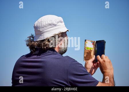 Homme prenant une photo avec un téléphone portable Banque D'Images