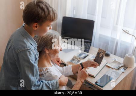 Grand-mère avec arrière-petit-fils regardant de vieilles photos Banque D'Images