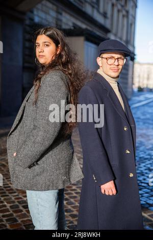 Deux jeunes amis posant dos à dos, femme nord-africaine et homme danois, amitié multiethnique Banque D'Images