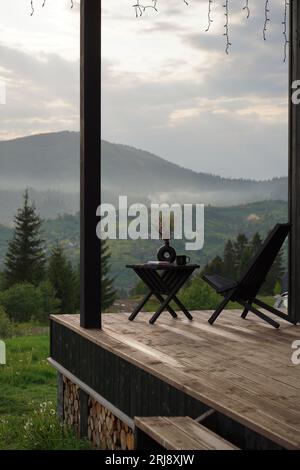 Chaise en bois moderne sur la terrasse avec vue sur la montagne brumeuse en Ukraine Banque D'Images