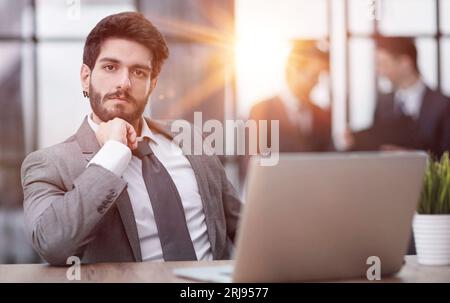 Jeune homme d'affaires réfléchi directeur exécutif portant un costume travaillant dans un bureau moderne Banque D'Images