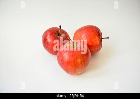 One big appetizing red apple in front of two red apples isolated on white background Banque D'Images