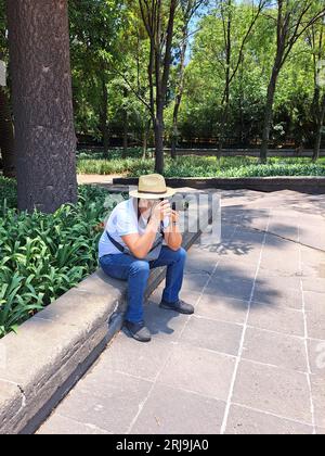 L'homme adulte latino-américain aux cheveux foncés est photographe en plein air avec appareil photo professionnel. Souriez ! Banque D'Images