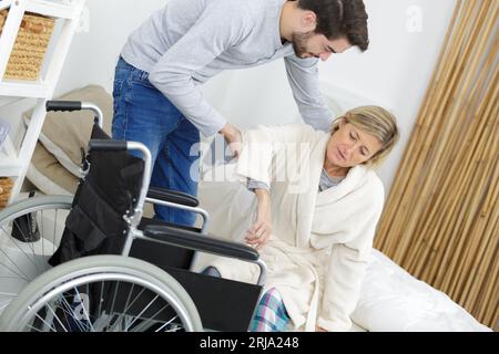 aider la femme à sortir du lit Banque D'Images