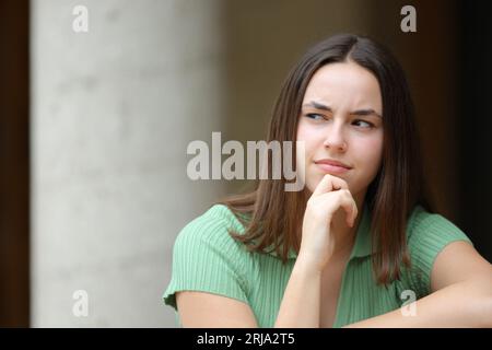 Portrait en vue de face d'une femme pensive dans la rue regarde sur le côté Banque D'Images