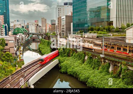 TOKYO, JAPON - AOÛT 09 2023 : image longue exposition (mouvement flou) de trains de métro et de train passant au-dessus de la rivière Kanda au pont Hijiribashi, Banque D'Images