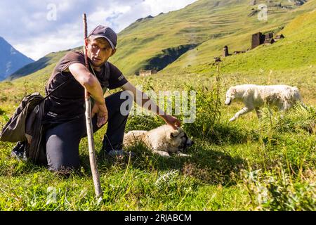 Seuls les bergers peuvent vraiment calmer leurs chiens à Tusheti. Ce berger câlins un chien qu'il utilise comme oreiller les nuits froides. Près de Dartlo, Géorgie Banque D'Images