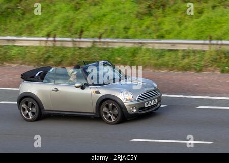 2009 Mini Cooper Silver car Cabriolet car essence 1598 cc voyageant à grande vitesse sur l'autoroute M6 dans le Grand Manchester, Royaume-Uni Banque D'Images