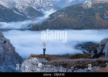 Un touriste solitaire se dresse au-dessus du brouillard au bord d'une falaise dans les montagnes Dolomites. Emplacement Auronzo rifugio dans le parc national de Tre cime di Lavaredo, Dolomites, Trentin-Haut-Adige, Italie Banque D'Images