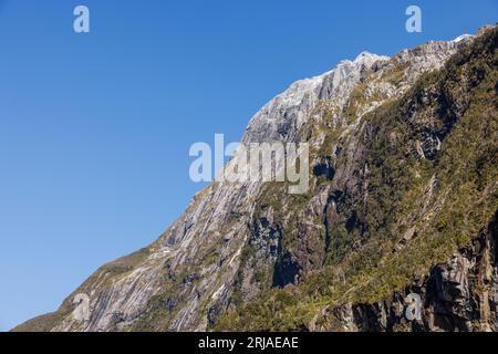 Une grande montagne et falaise avec de la neige au sommet. La falaise est extrêmement rocheuse et une partie de celle-ci est couverte de végétation luxuriante et verdoyante. La photo wa Banque D'Images