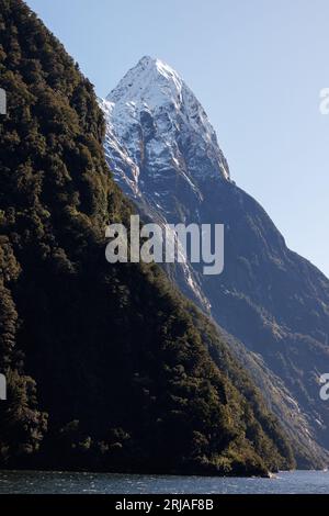 Mitre Peak se balançant derrière une autre colline. Mitre Peak est situé dans le Milford Sound, en Nouvelle-Zélande et couvert de neige Banque D'Images