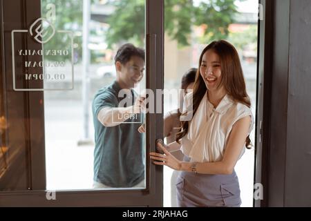 Groupe d'adolescents asiatiques entrant ensemble dans une boulangerie. Homme et femmes visitant un café avec le sourire Banque D'Images