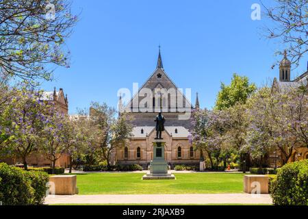 Adélaïde, Australie du Sud - 28 décembre 2022 : bâtiment du campus de la ville de l'Université d'Adélaïde avec un monument et des fleurs d'arbres jacaranda vues à travers G Banque D'Images