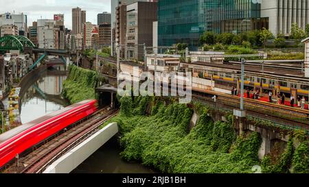 TOKYO, JAPON - AOÛT 09 2023 : image longue exposition (mouvement flou) de trains de métro et de train passant au-dessus de la rivière Kanda au pont Hijiribashi, Banque D'Images