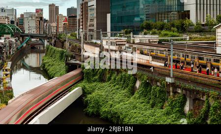 TOKYO, JAPON - AOÛT 09 2023 : image longue exposition (mouvement flou) de trains de métro et de train passant au-dessus de la rivière Kanda au pont Hijiribashi, Banque D'Images