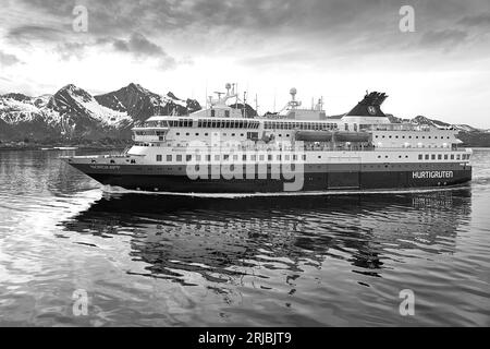 Gros plan Noir et photo du ferry norvégien Hurtigruten, MS NORDKAPP, sortant de Svolvaer, derrière les montagnes enneigées des îles Lofoten Banque D'Images