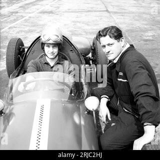 1962, historique, un jeune pilote masculin assis dans une voiture de course Cooper avec son instructeur, dans une école de pilotage à l'aérodome Finmere, Bucks, Angleterre, Royaume-Uni. L'ancienne base de la RAF construite en 1942 avait trois pistes en béton utilisées par l'école de pilotes de course automobile créée par Geoff Clarke. Banque D'Images