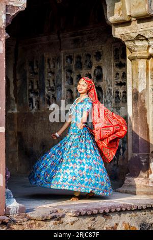 Une jolie jeune femme locale portant un voile rouge de style local et une robe bleue dans le fort de Ranthambore, parc national de Ranthambore, Rajasthan, nord de l'Inde Banque D'Images
