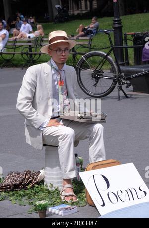 Un homme américain d'origine asiatique à Washington Square Park écrit des poèmes personnels et sollicite des dons. En août 2023 à Manhattan. Banque D'Images