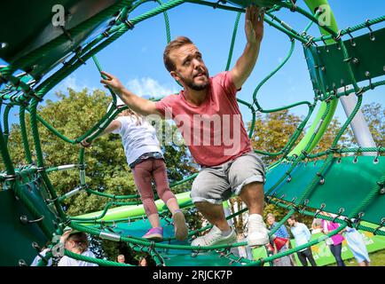 Brême, Allemagne. 22 août 2023. Mathias Mester, multiple champion du monde para de lancer de javelot, tente un cadre d’escalade à l’ouverture de la première aire de jeux inclusive à Brême, à la garderie de la congrégation de l’église Dietrich Bonhoeffer. L'aire de jeux offre également un accès sans obstacle à divers équipements de jeux pour les enfants handicapés. Crédit : Focke Strangmann/dpa/Alamy Live News Banque D'Images