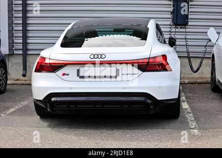 Blanc Audi e-tron GT RS F83 voiture électrique garée près d'un chargeur mural d'un concessionnaire automobile, vue arrière. Salo, Finlande. 13 août 2023. Banque D'Images