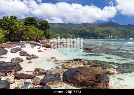 Sable blanc et pierres côtières de la plage de beau Vallon, Seychelles. Photo de paysage naturel prise par une journée ensoleillée d'été Banque D'Images