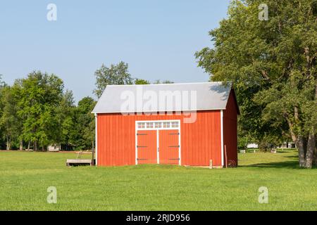 Vieille grange rouge et vieux matériel agricole rouillé dans l'Illinois rural. Banque D'Images