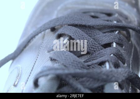 Une photo des lacets de chaussures noirs de l'école d'un élève sur un fond blanc. Banque D'Images